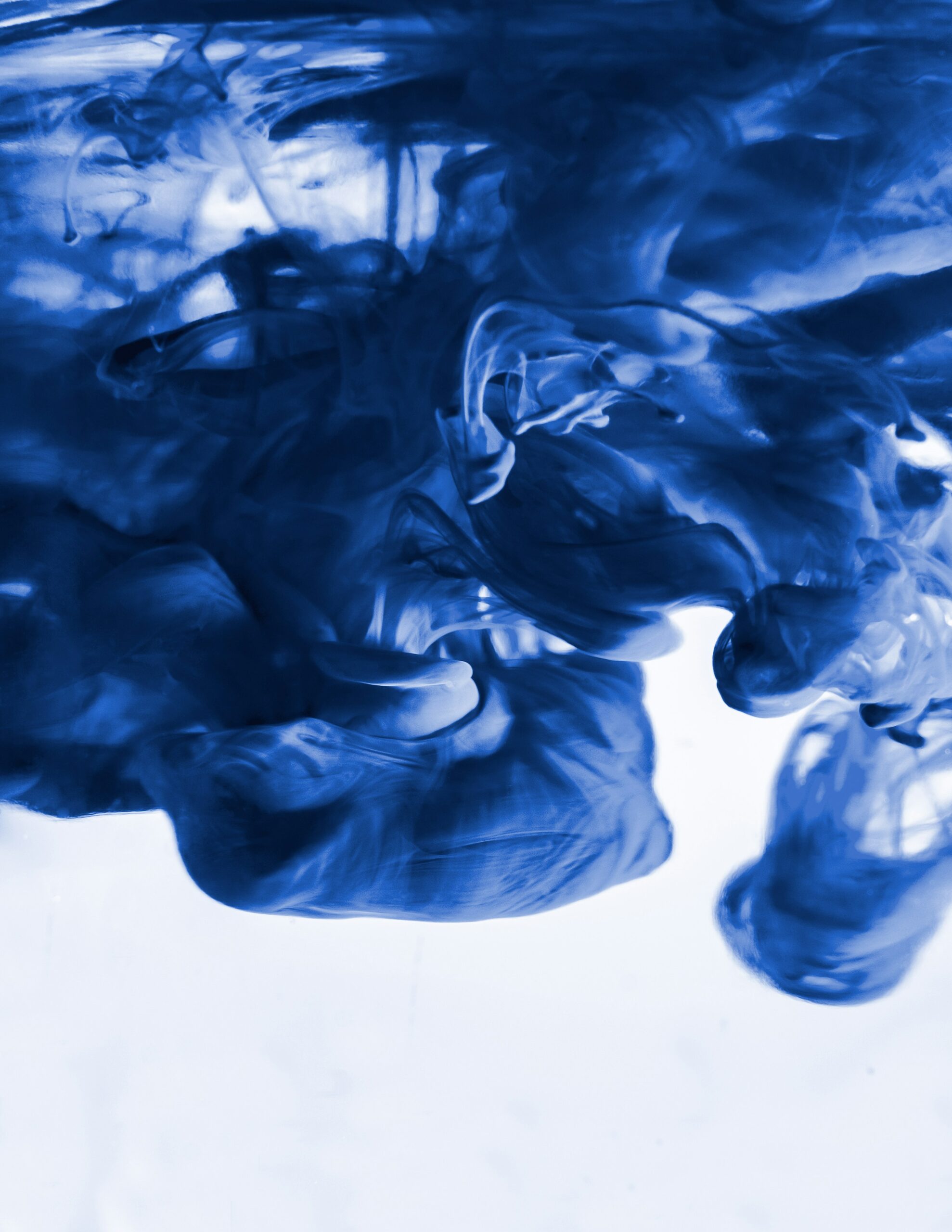 A photo of blue ink moving through water in a billowing pattern.