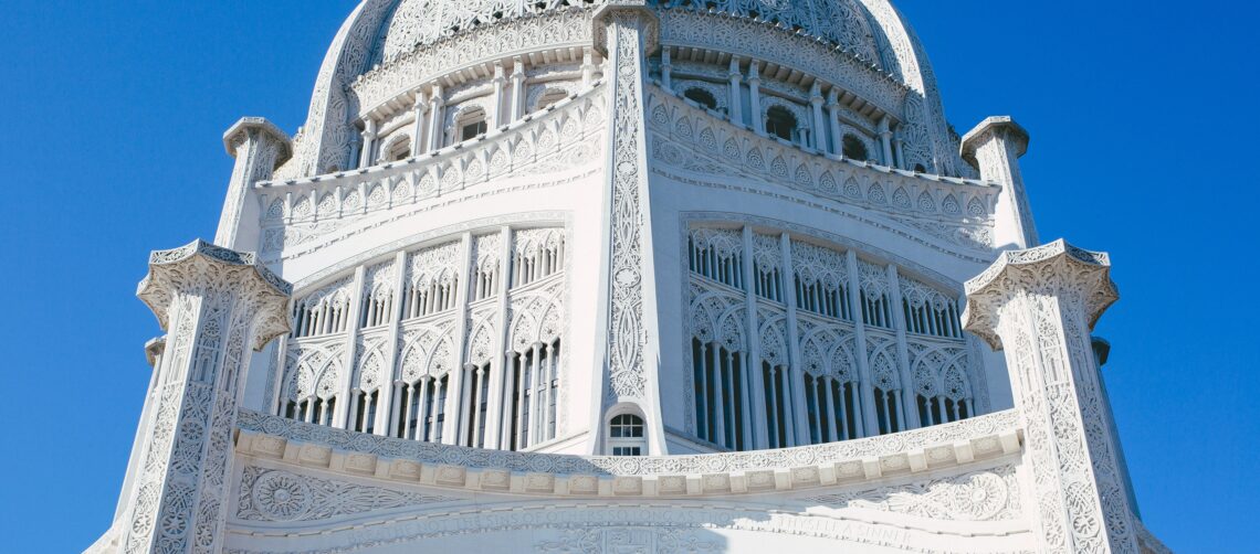 A photo of the Bahá'í House of Worship, Linden Avenue, Wilmette, IL, USA, on a blue sky background.