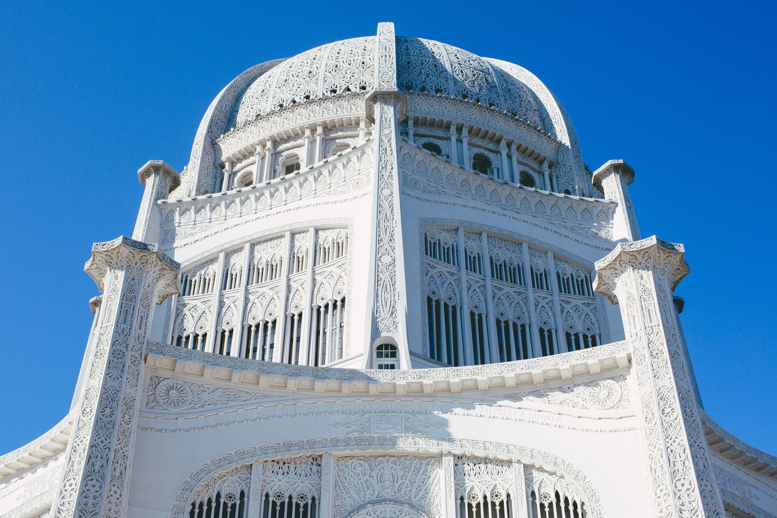 A photo of the Bahá'í House of Worship, Linden Avenue, Wilmette, IL, USA, on a blue sky background.